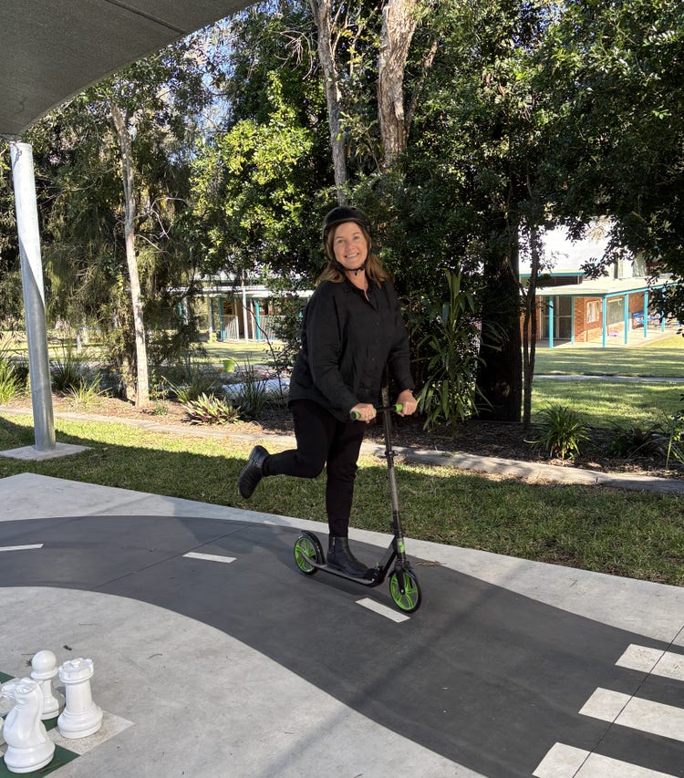 A staff member riding a scooter in the playground