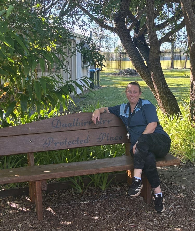 A school community member sitting in a garden seat