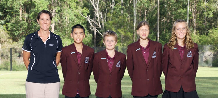 An image of the school principal standing beside four student leaders in blazers